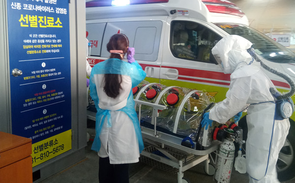 정부가 코로나19 확진자 응급진료를 위한 대책을 내놓았지만 현장에서는 미봉책에 불과하다는 비판이 나왔다. 사진은 코로나19 유행 초기 119구급대가 코로나19 확진자를 이송하는 모습. 