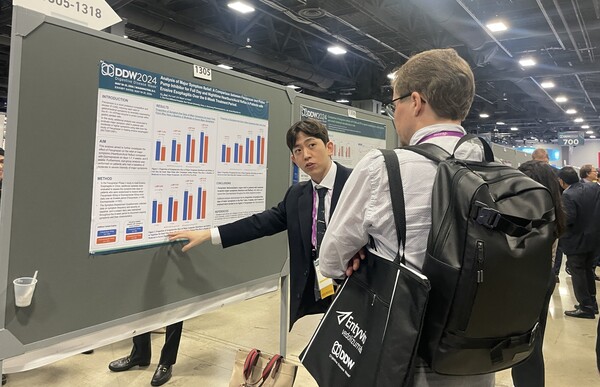 대웅제약 문석용 임상연구팀원(왼쪽)이 20일(현지시간) 해외 의료진에 펙수클루의 주증상 완화율 관련 포스터를 소개하고 있다. (사진제공: 대웅제약)