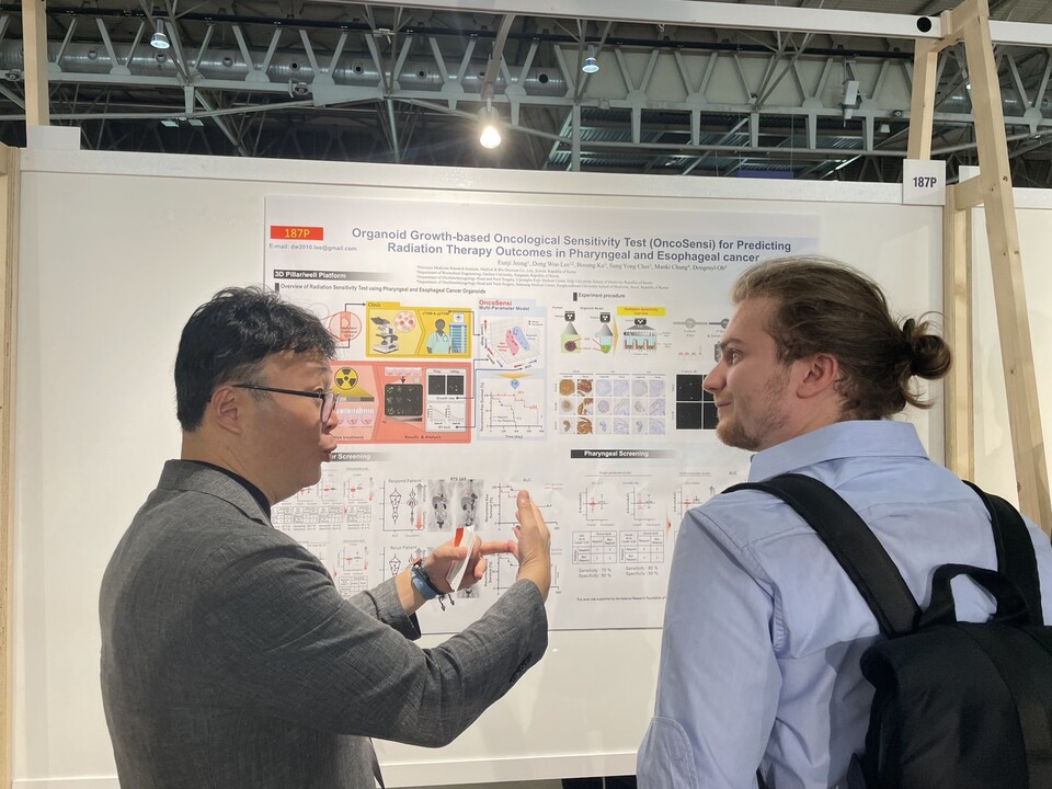 엠비디 임재균 부사장이 유럽종양학회 연례학술대회(ESMO 2024)에서 참관객에게 포스터에 대해 설명하고 있다.  