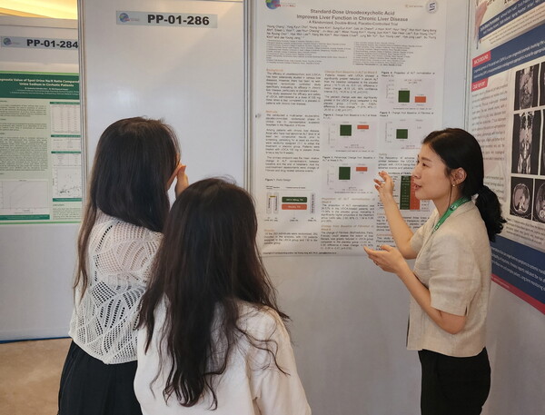 대웅제약 유정민 임상연구팀원(오른쪽)이 APDW 2024에서 우루사 4상 관련 포스터를 소개하고 있다. (사진 제공: 대웅제약)