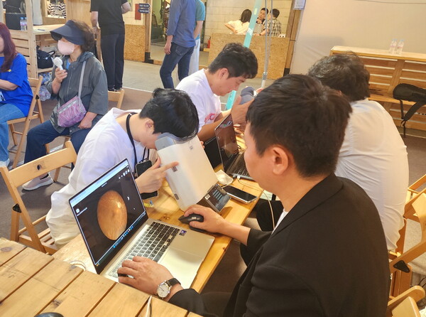 대웅제약 부스 방문객이 위스키와 옵티나를 활용해 안저 상태를 확인하고 있다.